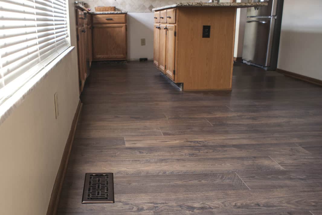 Same kitchen with dark wood-look LVT flooring after installation